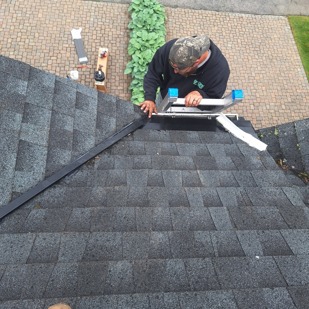 Roofer installing ice melt panels on a home's roof.